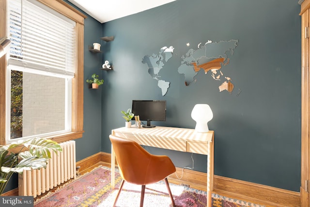 office space featuring radiator heating unit and hardwood / wood-style flooring