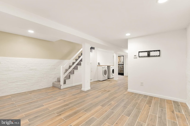 basement with light wood-type flooring and washing machine and clothes dryer