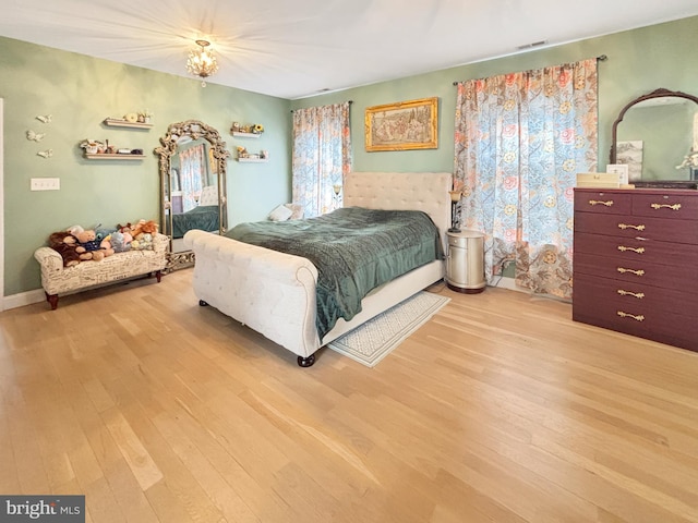 bedroom featuring light hardwood / wood-style floors and an inviting chandelier