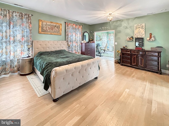 bedroom featuring a notable chandelier and light hardwood / wood-style flooring