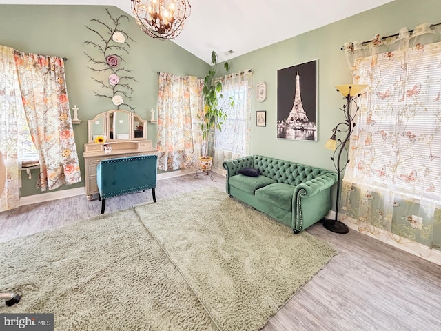 sitting room featuring lofted ceiling, hardwood / wood-style flooring, and a chandelier