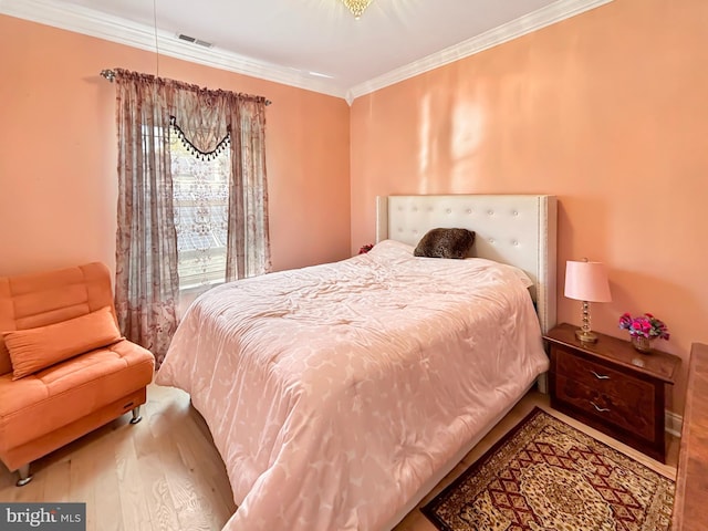 bedroom with wood-type flooring and ornamental molding