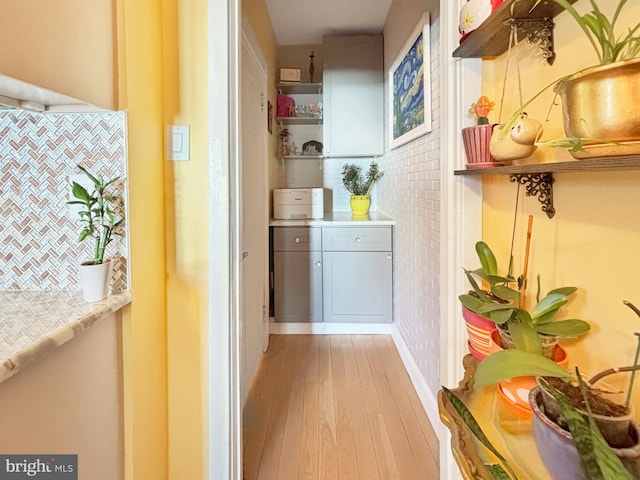 hallway featuring tile walls and light wood-type flooring