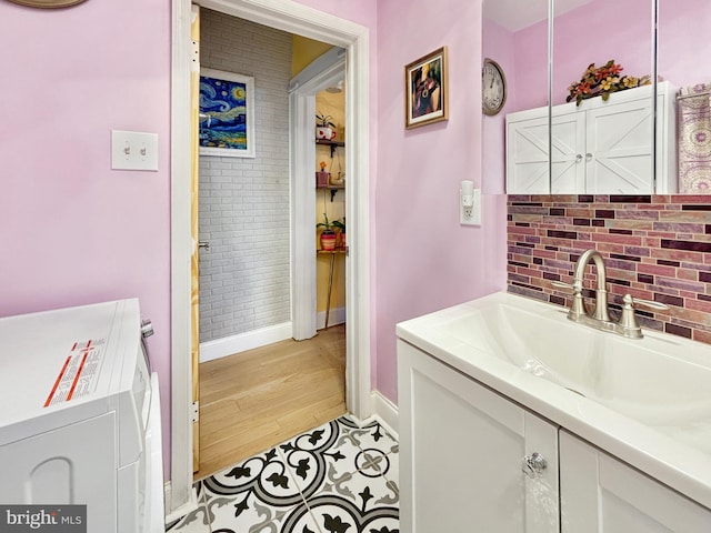 bathroom featuring vanity, hardwood / wood-style flooring, and washer / clothes dryer