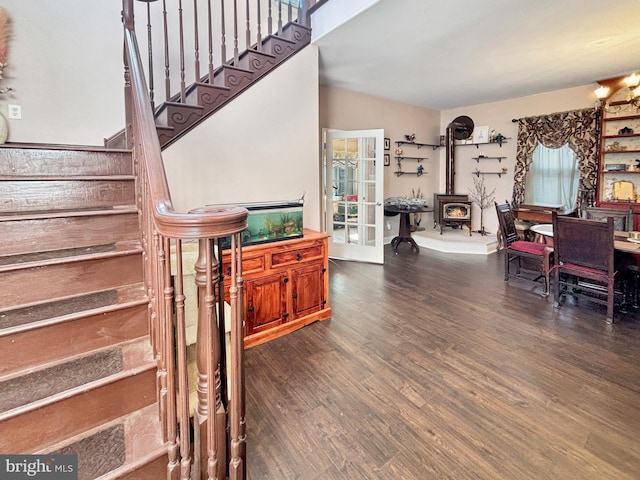 staircase with a wood stove and wood-type flooring