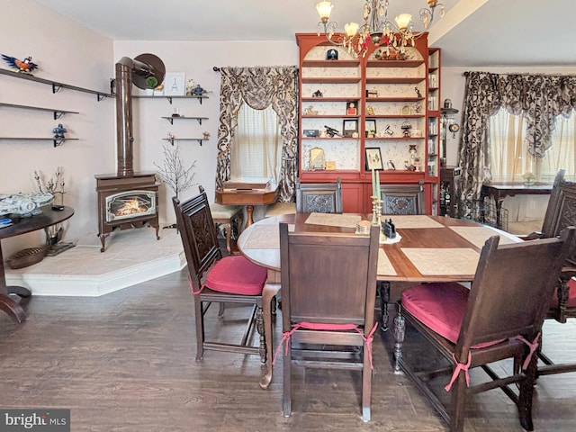 dining area featuring dark wood-type flooring, a wood stove, and a chandelier