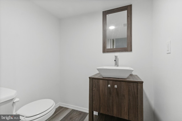 bathroom with vanity, hardwood / wood-style flooring, and toilet