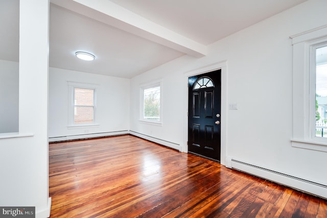 foyer with beamed ceiling, a baseboard radiator, plenty of natural light, and hardwood / wood-style floors