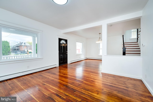 entrance foyer featuring hardwood / wood-style flooring, baseboard heating, and a wealth of natural light