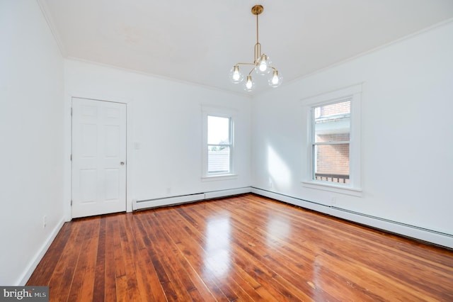 unfurnished room featuring crown molding, hardwood / wood-style flooring, a chandelier, and a wealth of natural light