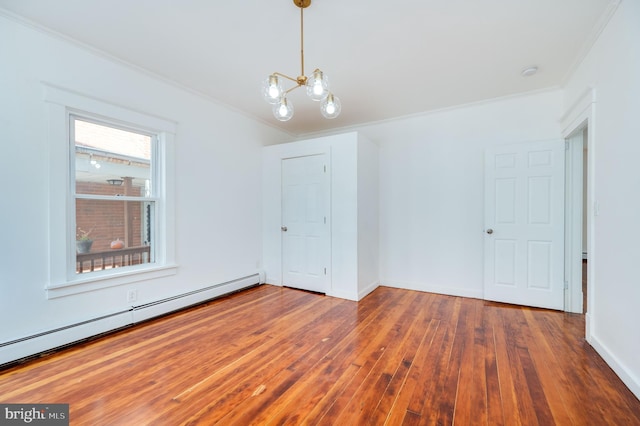 spare room featuring crown molding, a baseboard heating unit, a chandelier, and dark hardwood / wood-style floors