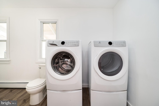 clothes washing area featuring dark wood-type flooring, separate washer and dryer, and baseboard heating