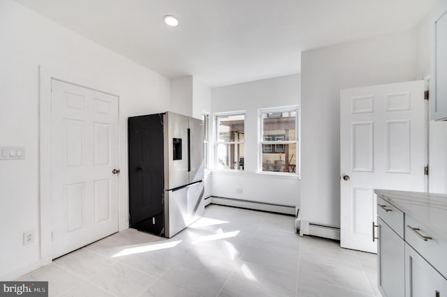 bedroom with light tile patterned floors, a baseboard radiator, and stainless steel fridge with ice dispenser