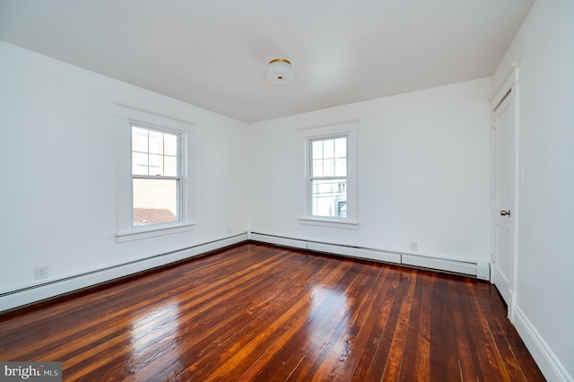 spare room with dark hardwood / wood-style floors and a baseboard heating unit