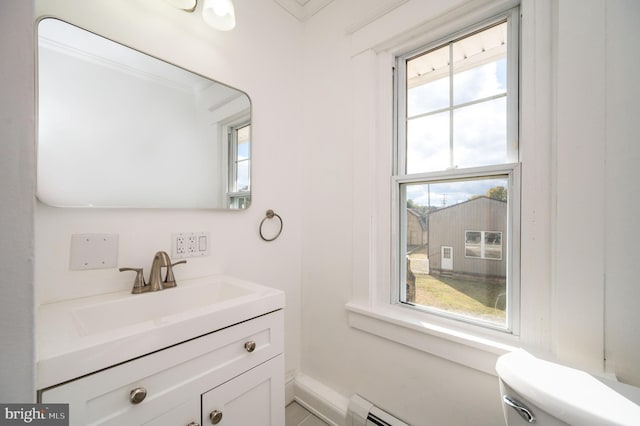 bathroom with vanity, toilet, ornamental molding, and a wealth of natural light