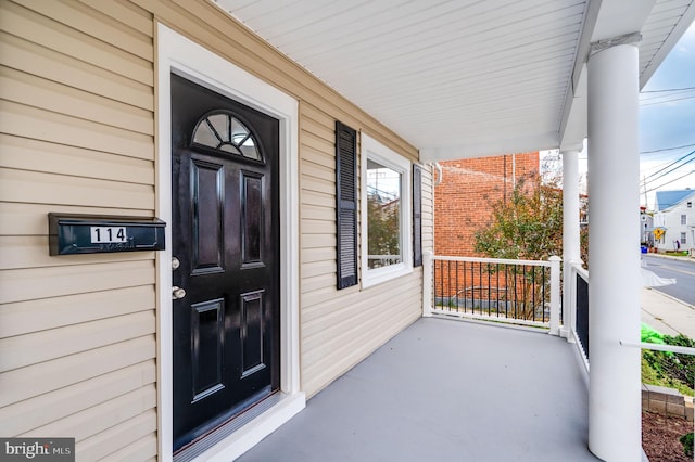 view of exterior entry featuring covered porch