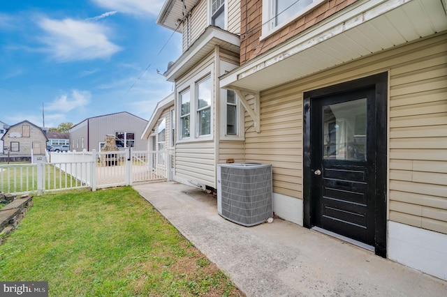 doorway to property with a yard and central air condition unit