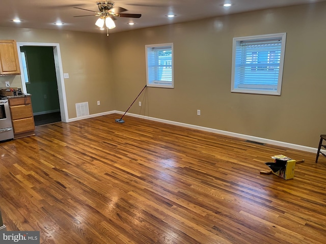 interior space with dark wood-type flooring and ceiling fan