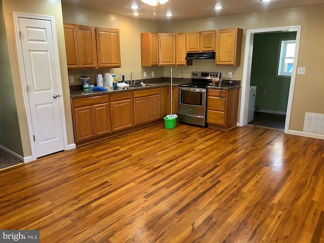 kitchen featuring dark hardwood / wood-style floors, sink, stainless steel electric range oven, and ceiling fan