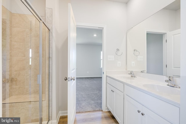 bathroom featuring vanity, hardwood / wood-style flooring, and a shower with shower door