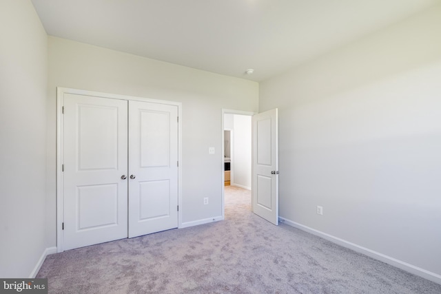 unfurnished bedroom with light carpet and a closet