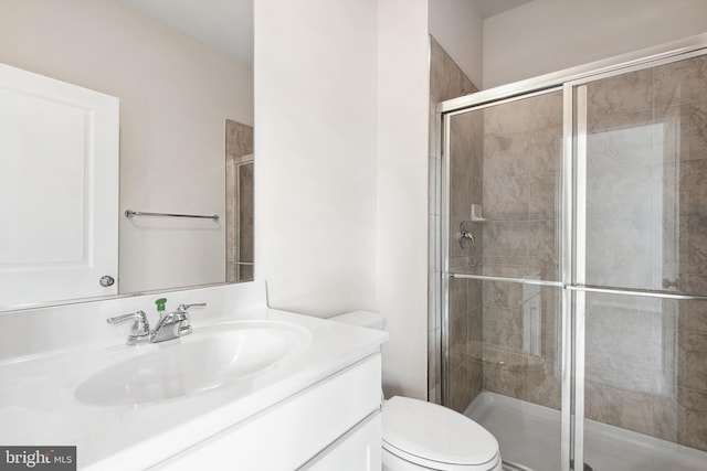 bathroom with vanity, toilet, and a shower with shower door