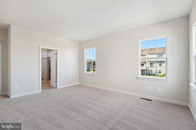 spare room featuring light carpet