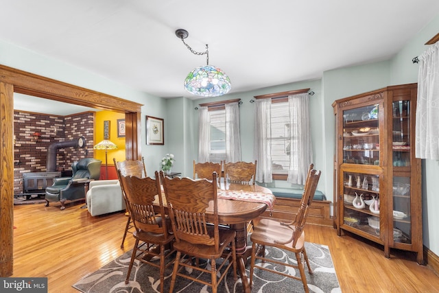 dining room featuring light hardwood / wood-style flooring and a wood stove