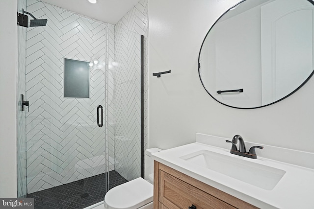 bathroom with vanity, toilet, and a shower with shower door