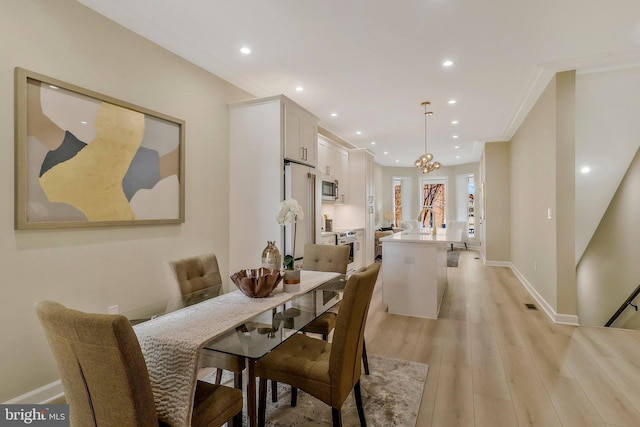 dining area featuring crown molding and light wood-type flooring