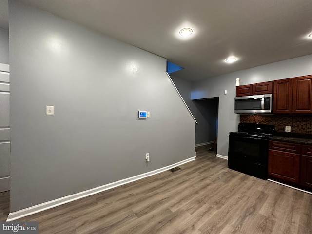 kitchen with black range with electric stovetop, light wood-type flooring, and backsplash