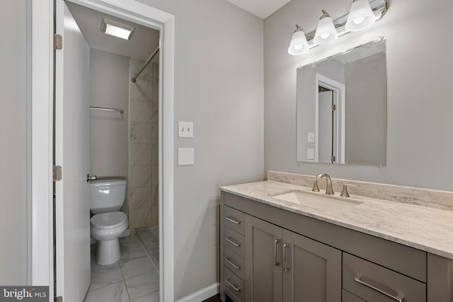 bathroom featuring vanity, toilet, and tiled shower