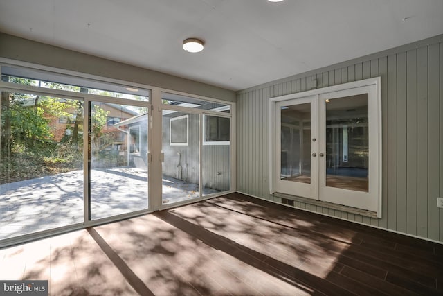 entryway featuring french doors, hardwood / wood-style flooring, and wood walls