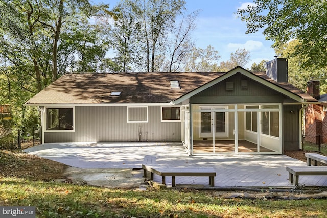 back of property with a deck, a patio, and a sunroom