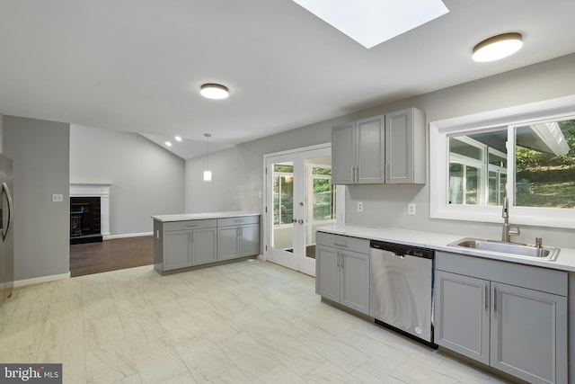 kitchen featuring gray cabinetry, sink, dishwasher, french doors, and hanging light fixtures