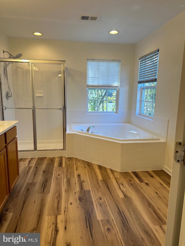 bathroom featuring vanity, independent shower and bath, and wood-type flooring