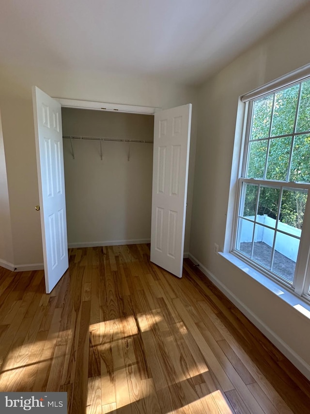 unfurnished bedroom featuring a closet and light hardwood / wood-style floors