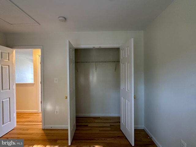 unfurnished bedroom featuring a closet and hardwood / wood-style flooring