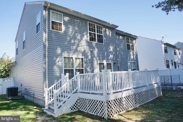 rear view of property with central air condition unit, a deck, and a yard