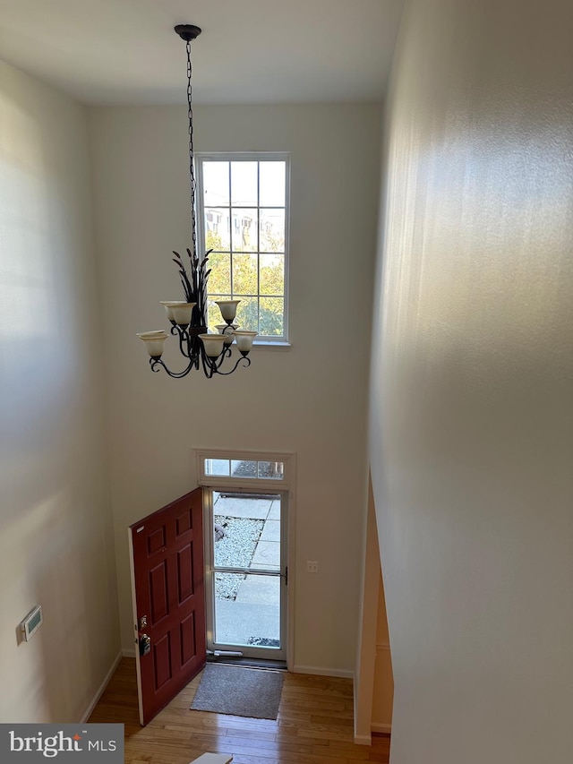 foyer entrance with an inviting chandelier and hardwood / wood-style floors