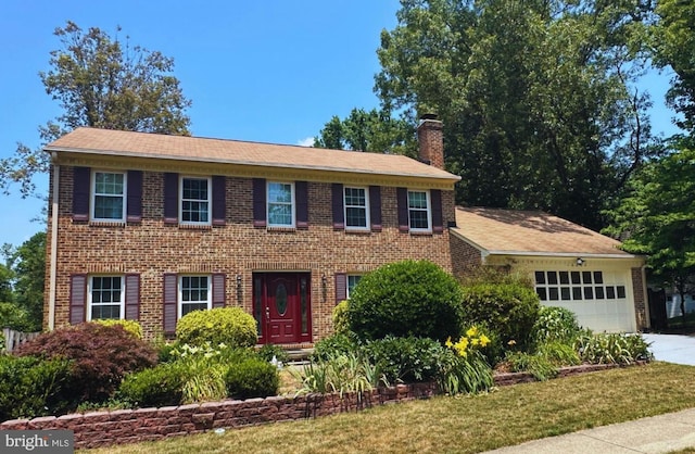 colonial home with a front yard and a garage