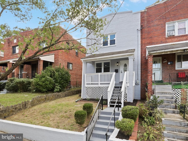 view of front of home with a porch and a front yard