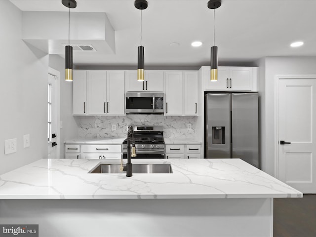 kitchen featuring white cabinetry, light stone counters, appliances with stainless steel finishes, and hanging light fixtures