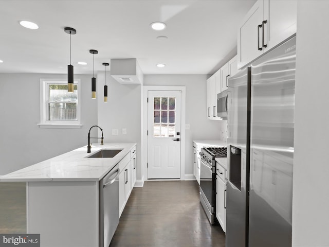 kitchen featuring white cabinets, light stone countertops, sink, decorative light fixtures, and stainless steel appliances