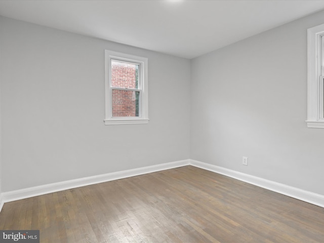 unfurnished room with hardwood / wood-style flooring