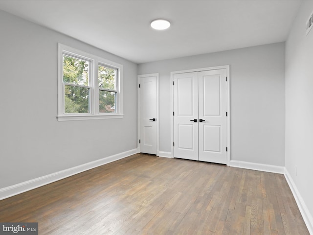 unfurnished bedroom with hardwood / wood-style flooring