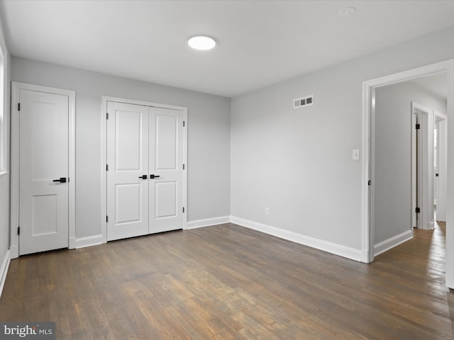 unfurnished bedroom featuring dark hardwood / wood-style flooring