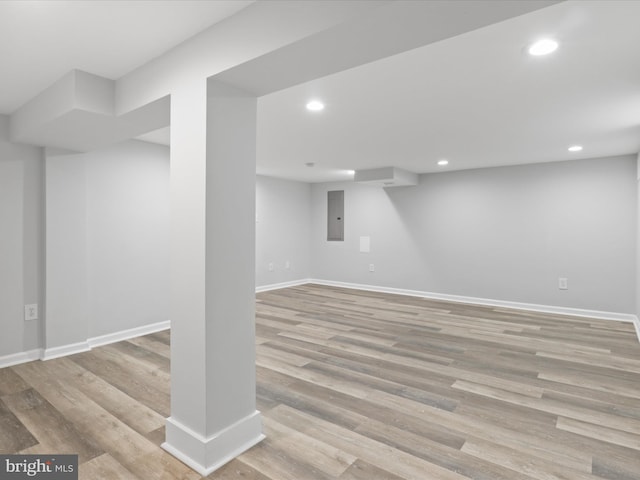 basement featuring light hardwood / wood-style floors and electric panel