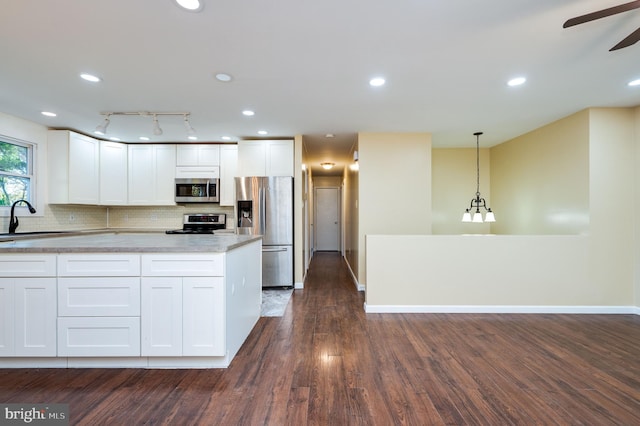 kitchen with white cabinets, pendant lighting, sink, and stainless steel appliances