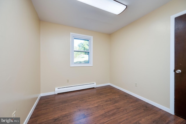 empty room featuring dark wood-type flooring and a baseboard radiator